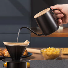 Pouring hot water from the kit kettle into its metal coffee dripper