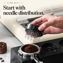 Needle distribution component held above coffee grounds